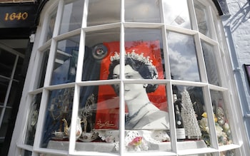 Mandatory Credit: Photo by OLIVIER HOSLET/EPA-EFE/Shutterstock (13382421y) A picture of Queen Elizabeth II is displayed in the window of a shop in Windsor, Britain, 11 September 2022. Britain's Queen Elizabeth II died at her Scottish estate on 08 September 2022. The 96-year-old queen was the longest-reigning monarch in British history. People pay their respects to late Queen Elizabeth II in Windsor, United Kingdom - 11 Sep 2022


