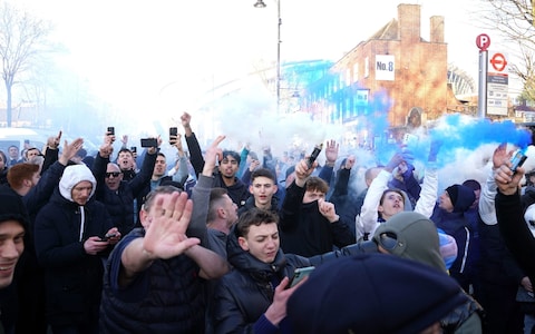 Fans set off smoke flares as they gather outside before the Premier League match at the Tottenham Hotspur Stadium,