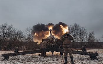 Ukrainian soldiers work in their artillery unit in the direction of Marinka